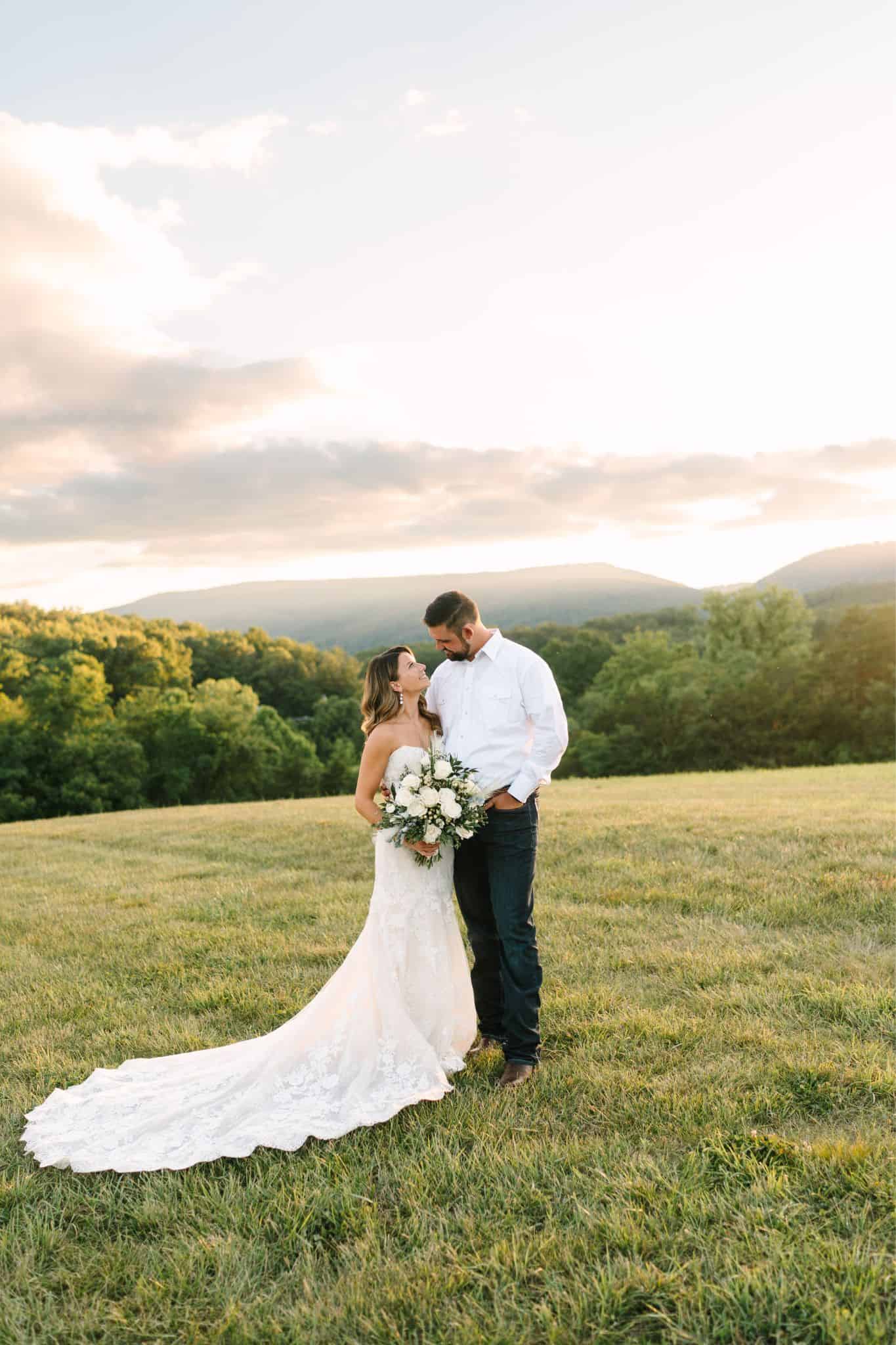 Just married couple posed on a hilltop at sunset with Blue Ridge Mountains in the background at Canaan Springs, a farm wedding venue in the Shenandoah Valley near the DMV area