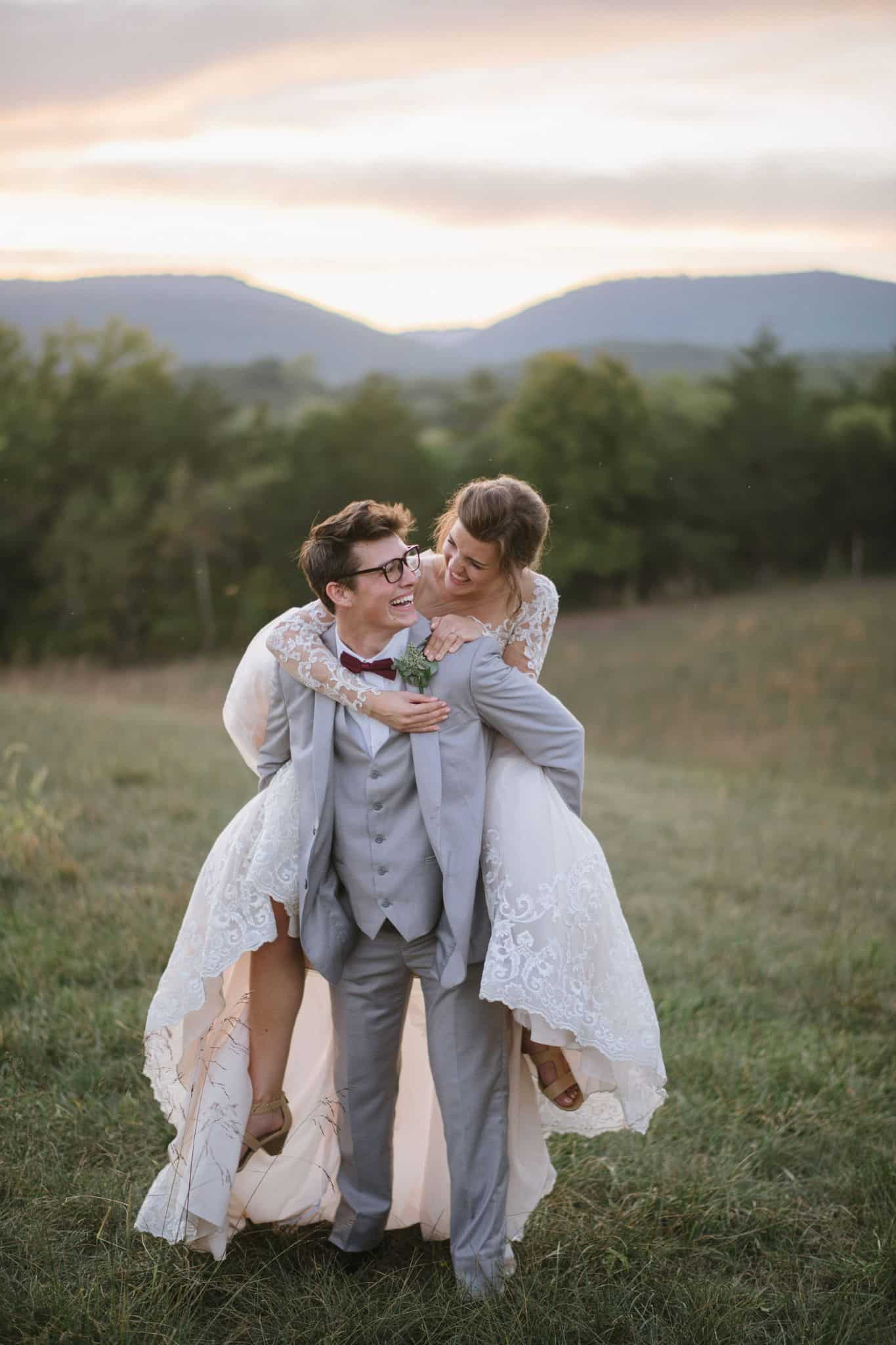 Just married couple laughing as the sun sets between the Blue Ridge Mountain peaks in Shenandoah Valley, Frederick County, at Canaan Springs farm wedding venue