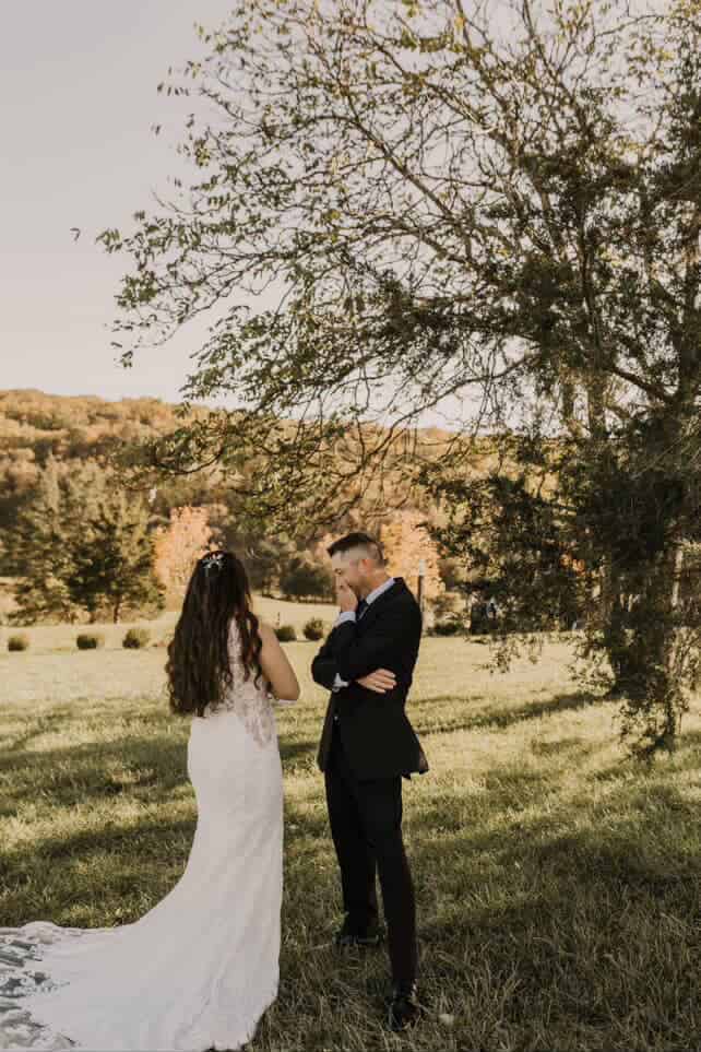 Bride and groom reading heartfelt letters to each other in a scenic field at Canaan Springs, a romantic farm wedding venue in Northern Virginia