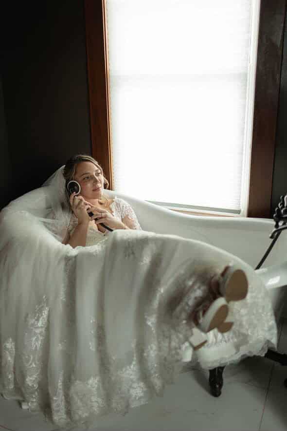 Bride relaxing in a vintage clawfoot tub inside the on-site Airbnb at Canaan Springs, a rustic farm wedding venue in Northern Virginia
