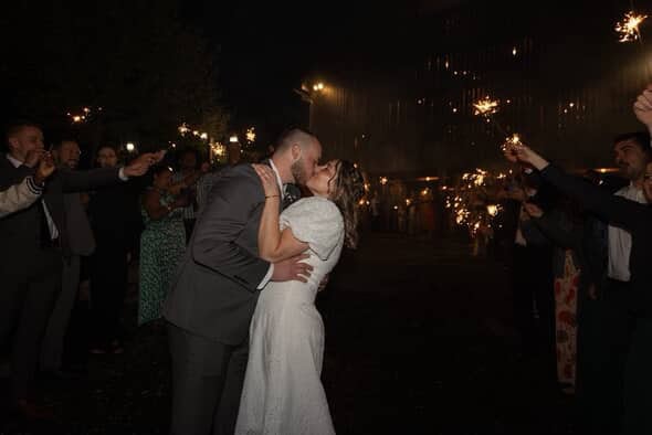 Just married couple kissing on the patio at Canaan Springs under a tunnel of sparklers, sharing a sweet moment as they leave for their honeymoon at this Northern Virginia farm wedding venue