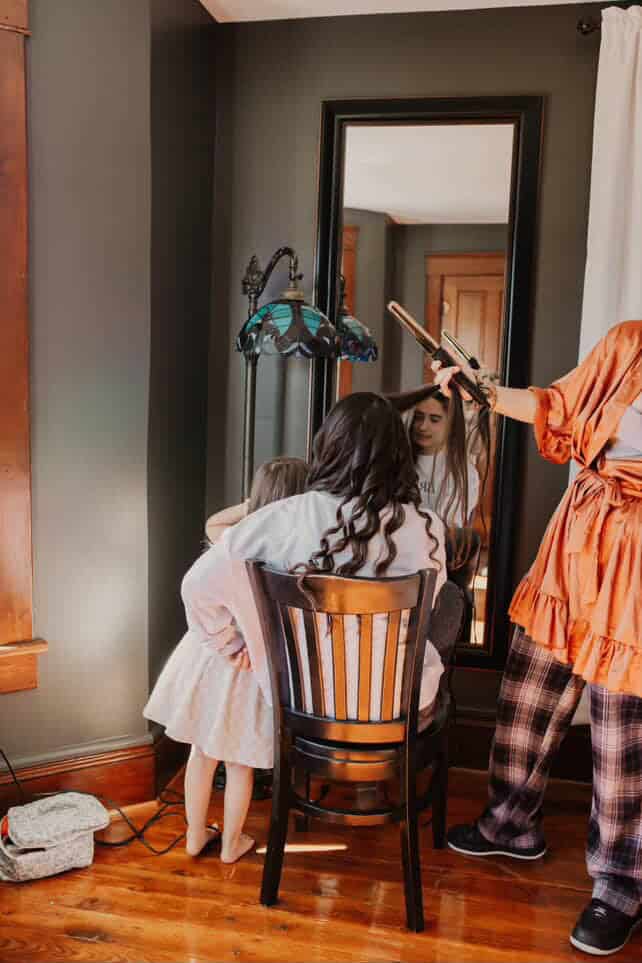 Bride getting her hair done in a spacious bedroom with a full mirror inside the farmhouse Airbnb at Canaan Springs, a rustic wedding venue in Northern Virginia