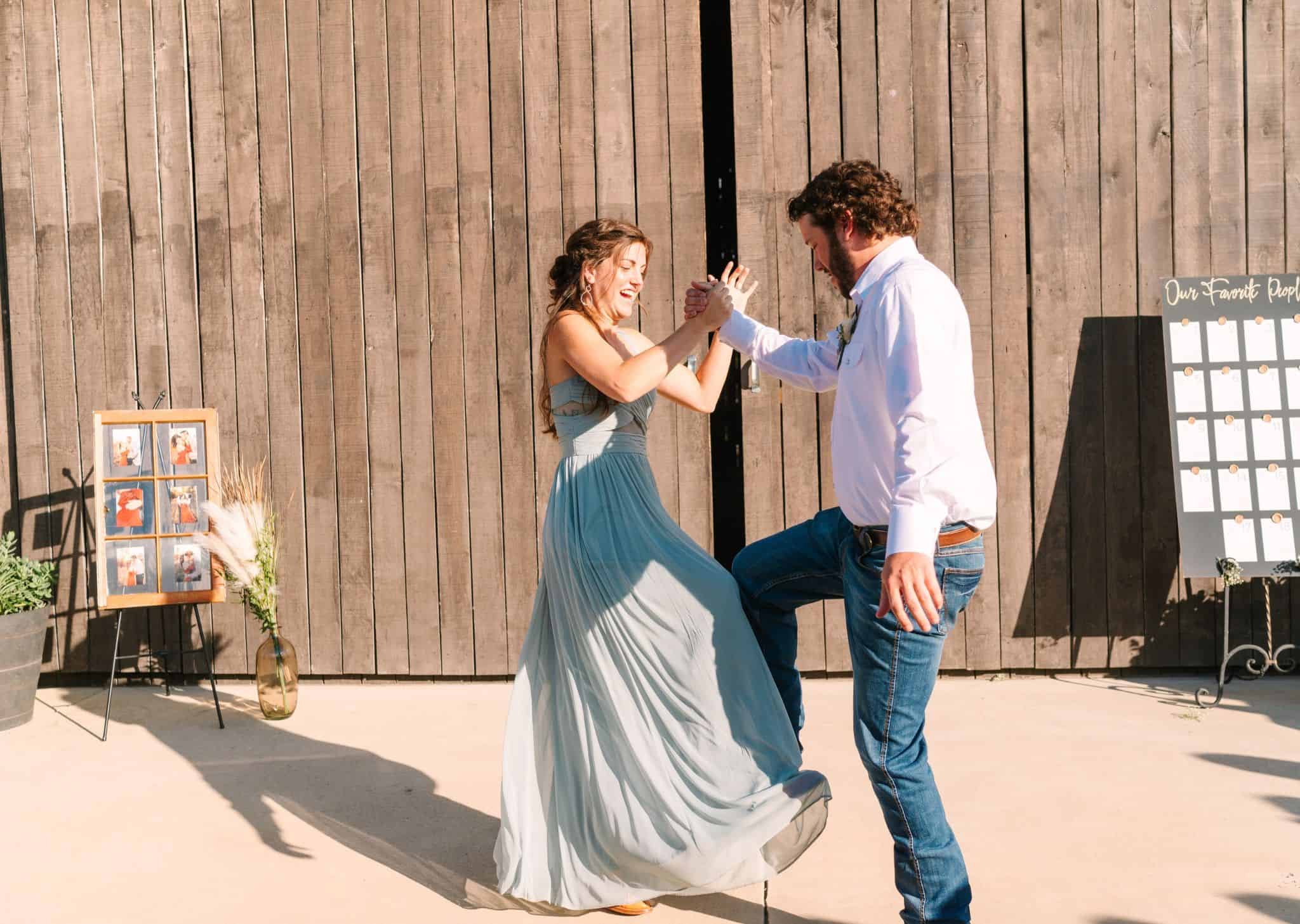Wedding party members dancing on the patio outside the barn at Canaan Springs, a rustic Northern Virginia farm wedding venue near Winchester, VA