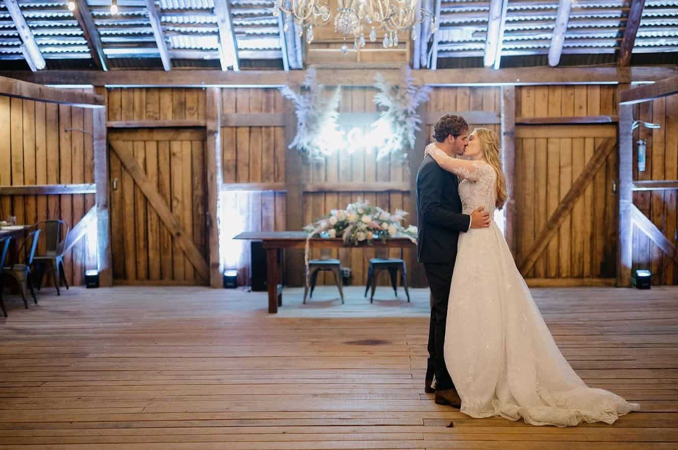 Bride and groom sharing a kiss in the barn at Canaan Springs after their first dance, a romantic Northern VA wedding venue near Winchester.