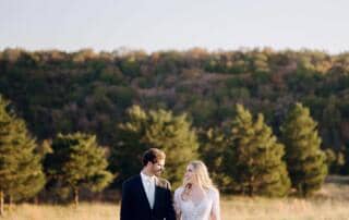 Just married couple walking through golden fields with mountain views at Canaan Springs, a Northern Virginia farm wedding venue near Winchester, Virginia